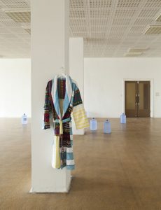 Towelling Bathrobe (Bademantel), hanging tailored garment, from found objects, 2016. Installation view at BARS AND CAFES, Haubrok Foundation, Berlin.